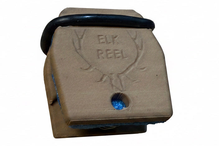 Brown elk call with 'Elk Reel' branding on a wooden surface