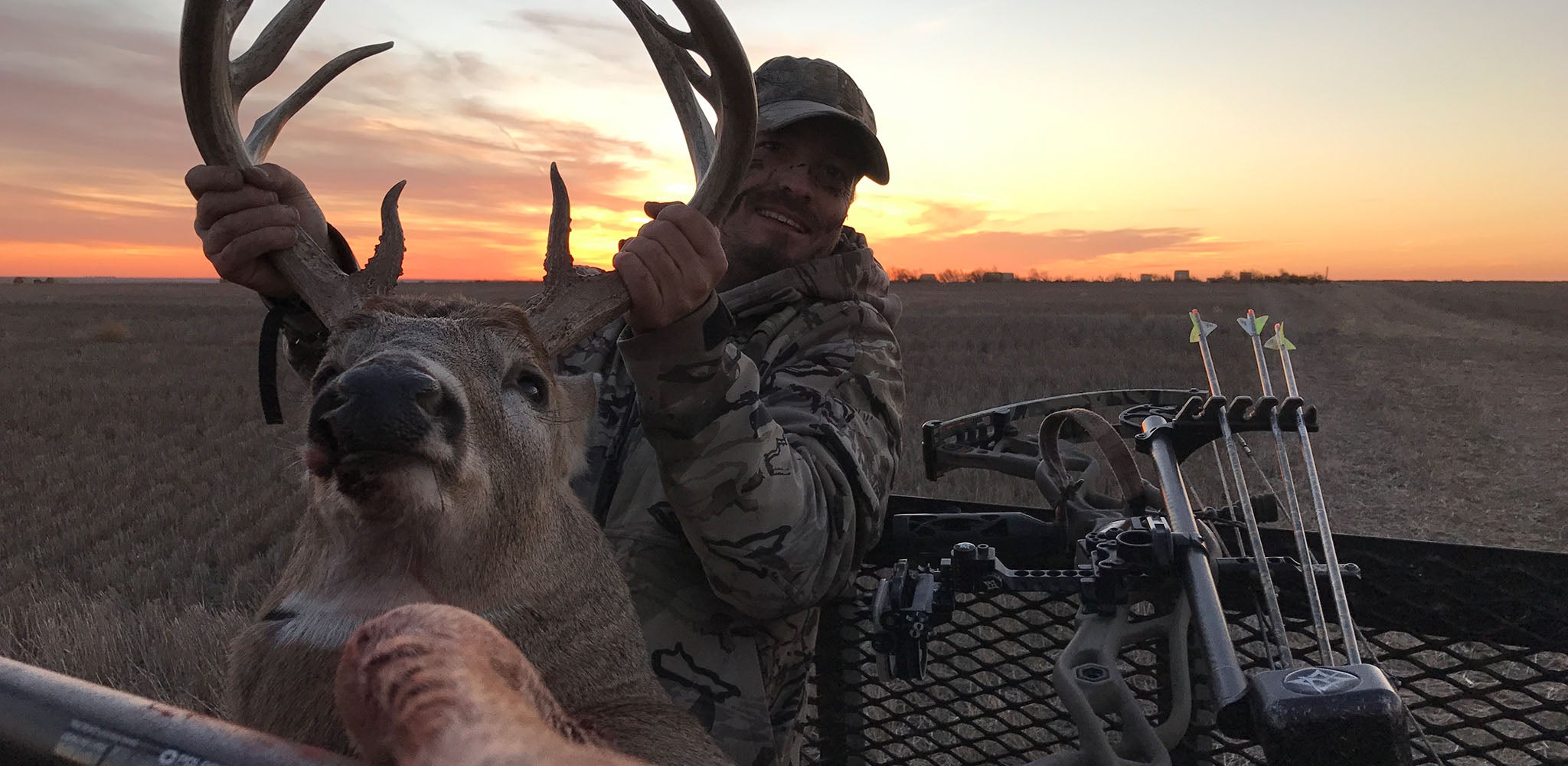 Founder Drew holding up an elk in a beautiful sunrise