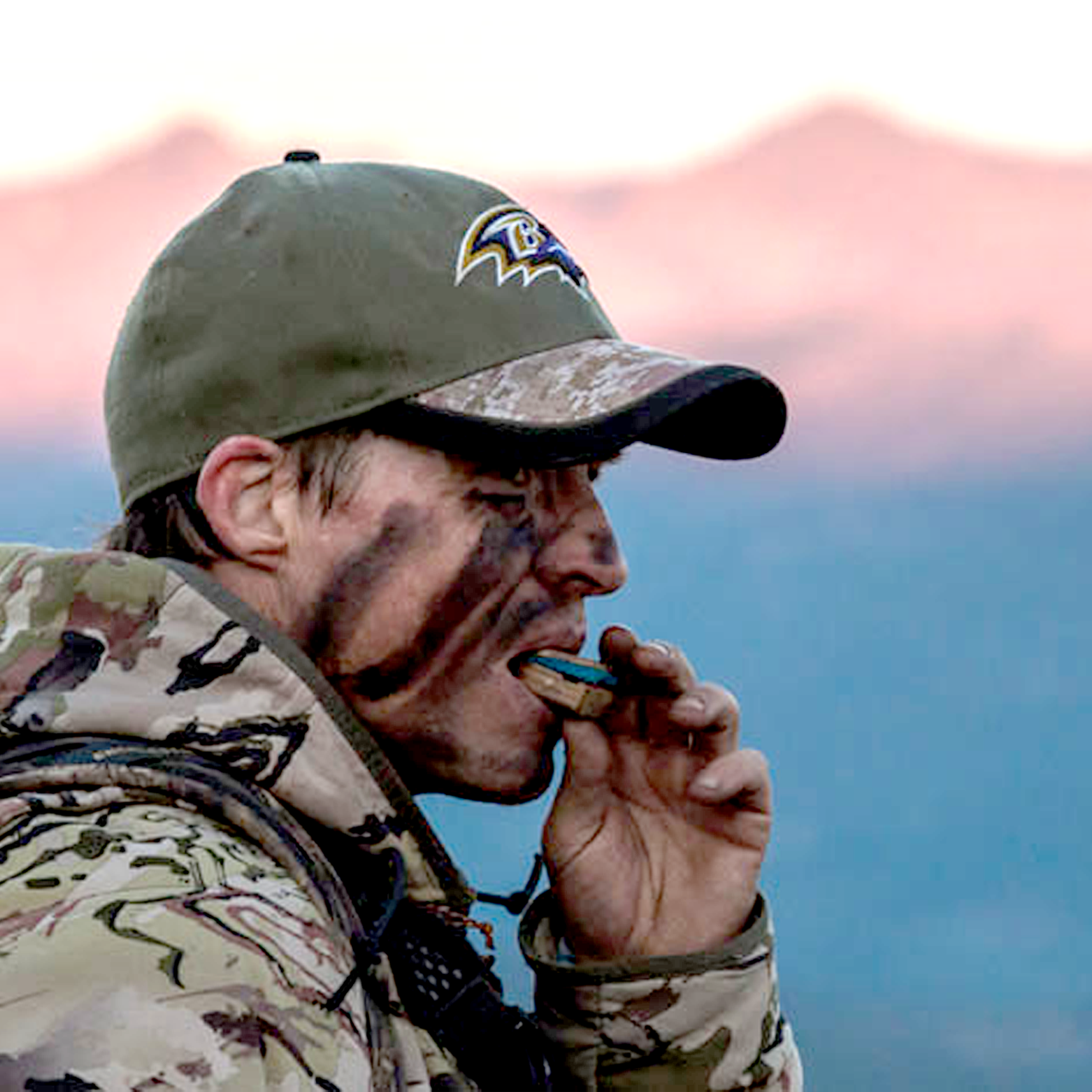 Another hunter using the Elk Reel classic call hardwood with his hands with the mountains behind